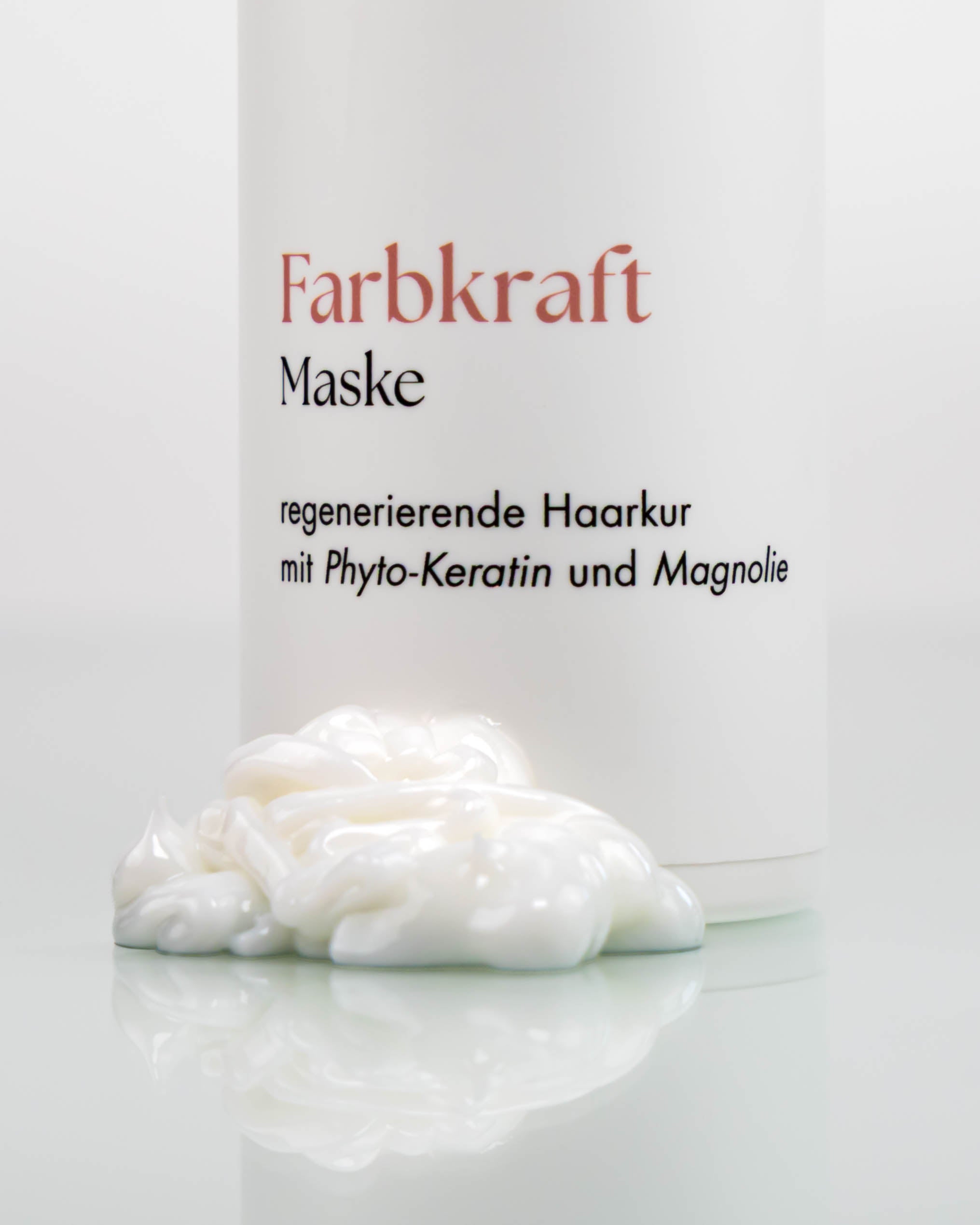 Flasche Farbkraftmaske vor der ein Häufchen Maske liegt