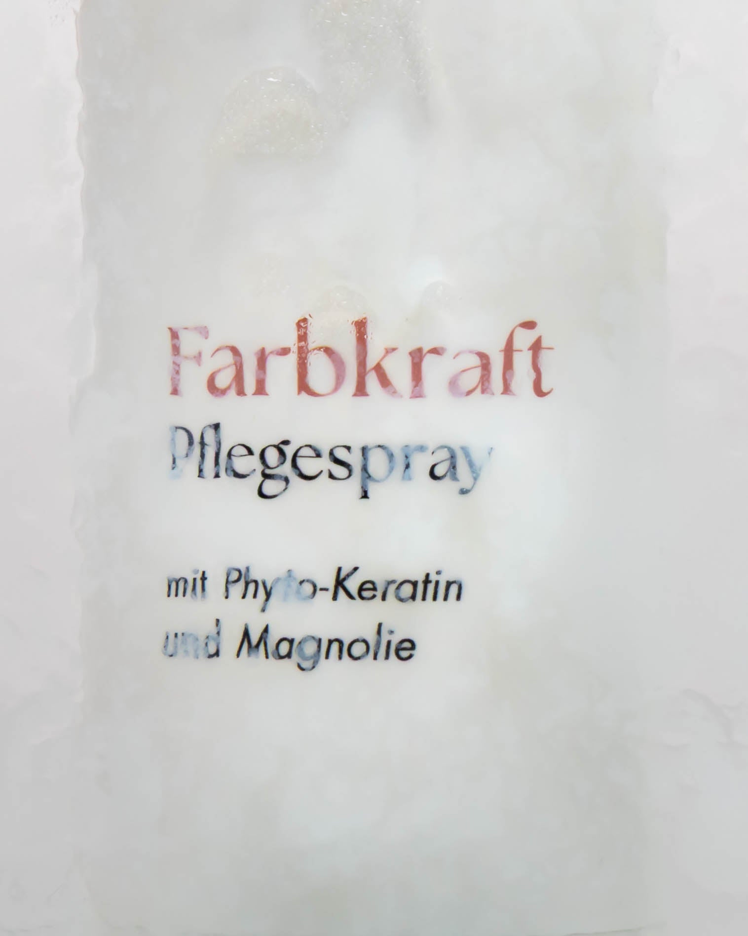 Flasche Farbkraftspray hinter besprühtem Glas