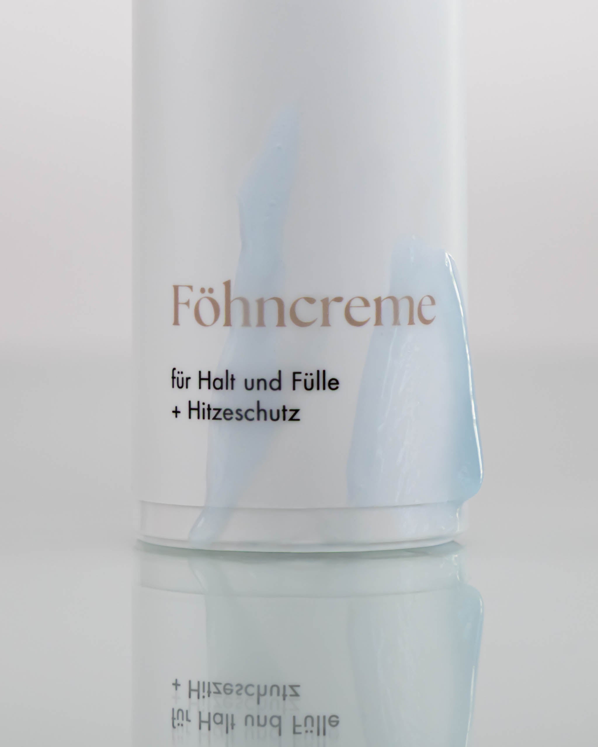Flasche Föhncreme, welche mit Föhncreme beschmiert wurde.