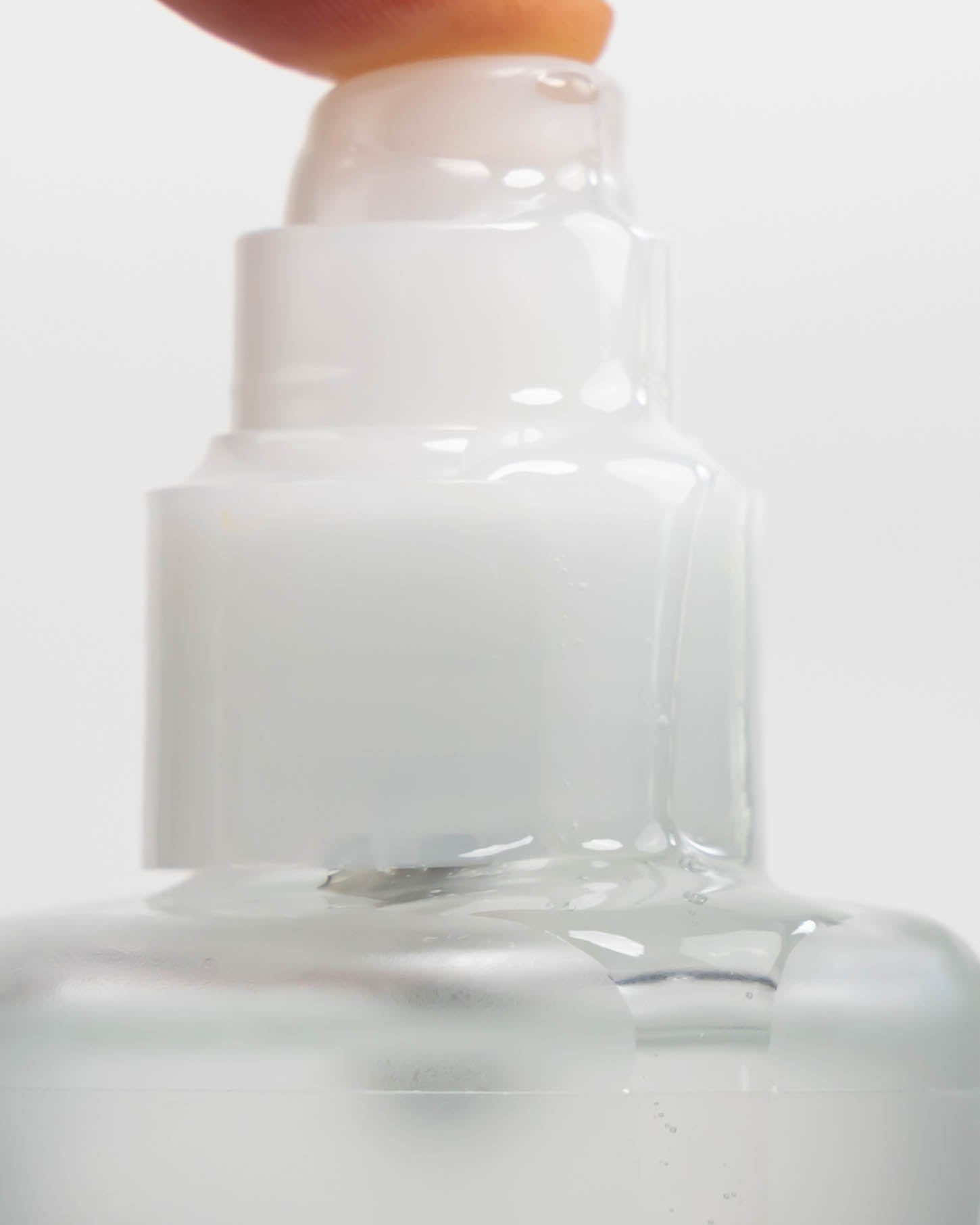 Flaschenkopf einer Haarölflasche aus dem Öl fließt