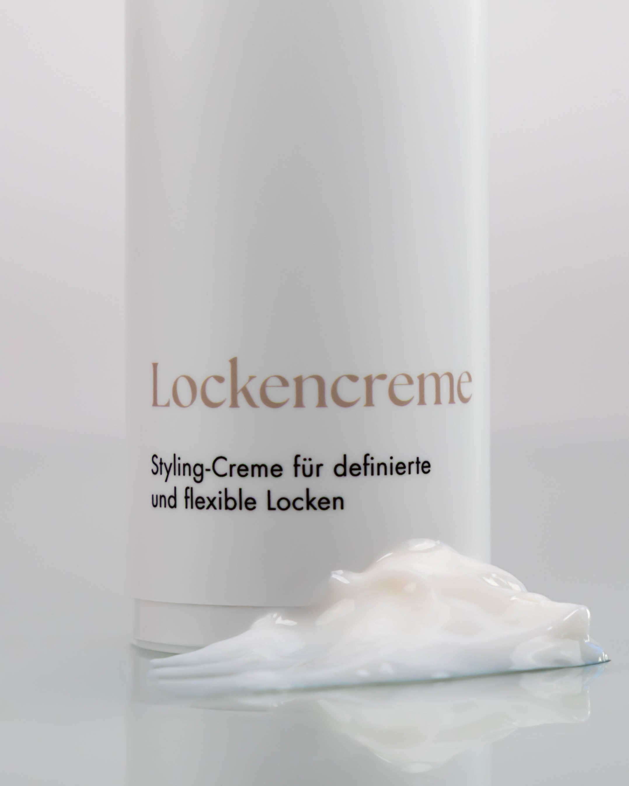 Flasche Lockencreme mit Cremehäufchen davor.
